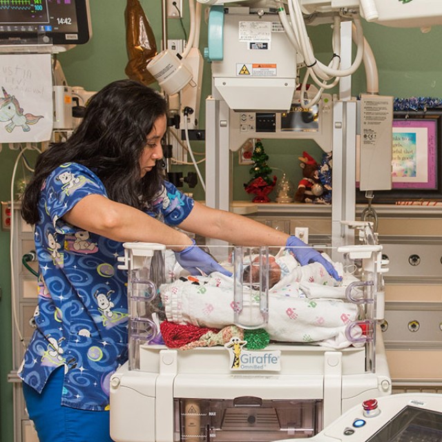 Hilda Rodriguez, RN, with radiology machine and infant in NICU