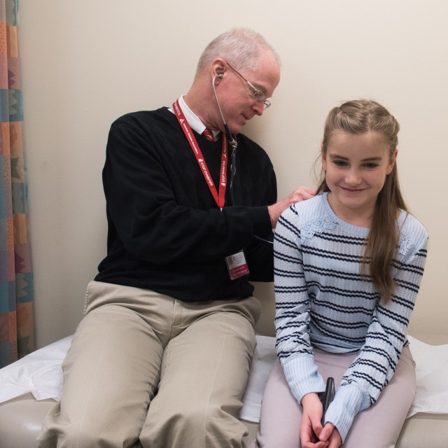 Christopher Clardy, MD, checking patient Gabrielle Mukenschnabl with a stethoscope