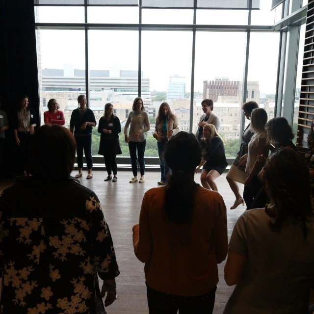 Female faculty standing in a circle in Logan Center