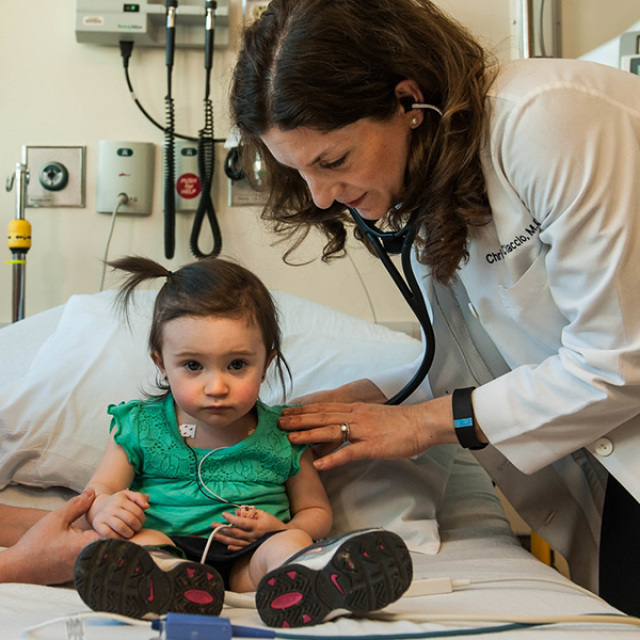 Physician listening to childs lungs with a stethoscope 