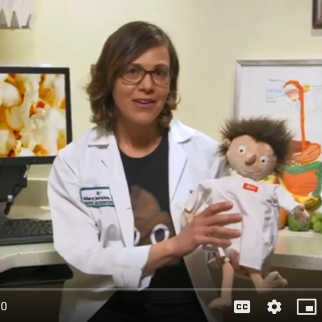 Doctor on a video holding a puppet and talking about constipation