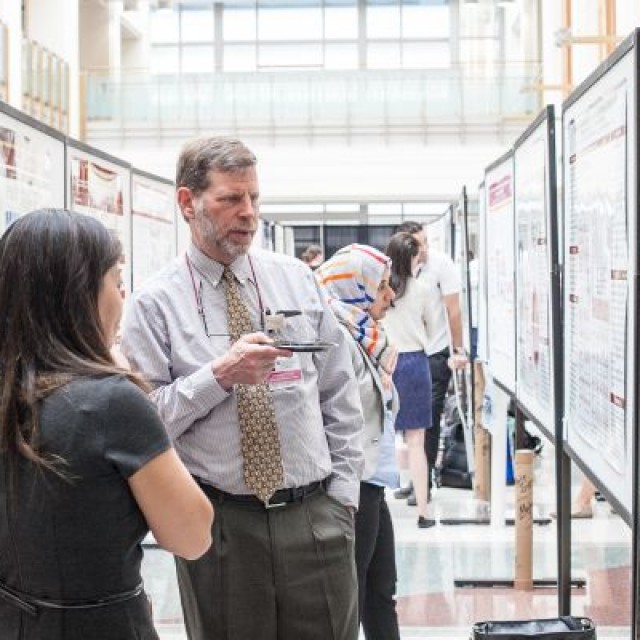 Miki Nishitani, MD and Daniel Johnson, MD viewing a poster at a research symposium